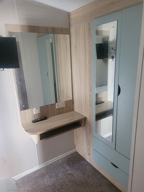 A bathroom with a wooden vanity, a mirror, a cabinet, and a towel rack. - Beautiful Caravan minutes from Cartmel & Grange-over-Sands, Lakes are nearby. (Flookburgh)