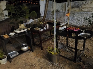 An outdoor dining area with tables, chairs, and various dishes. - St Andrews Coastal Retreat - Peaceful Stay in Trivandrum, Kerala (Trivandrum)