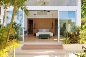 Een moderne slaapkamer met een groot bed, een inloopkast en uitzicht door glazen deuren.