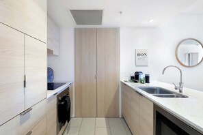 Eine moderne Küche mit eingebautem Ofen, einem Spülbecken und einem Holzschrank.