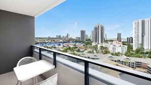A balcony with a view of a cityscape, including high-rise buildings and a body of water. - Ocean & River Views | Sauna + Steam Rm (Surfers Paradise)
