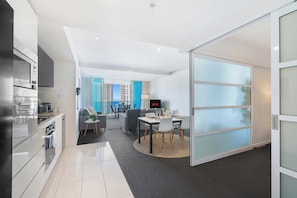 Ein modernes Apartment mit Küche, Essbereich und Wohnzimmer mit großem Fenster.