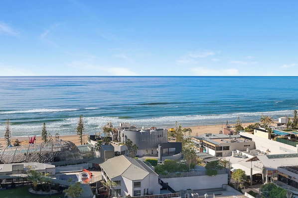 A coastal hotel with a view of the ocean, featuring modern architecture and a pool area. - Hilton 2BR Ocean Views, Pool+slide, Gym & Parking (Surfers Paradise)