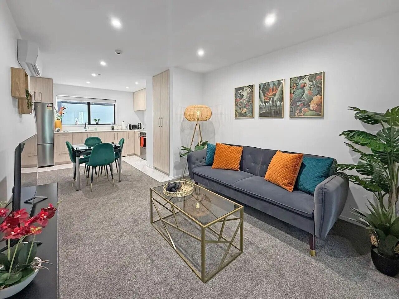 A modern living room with a sofa, coffee table, and dining area.
