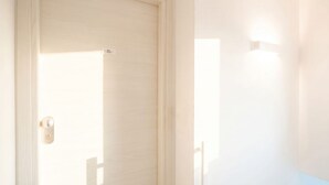 Uma porta fechada com um interruptor de luz e uma pequena etiqueta na porta.