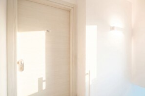 A closed door with a light switch and a small label on the door. - ALL BlueNote – 2 Bedrooms, 2 Baths & Stunning Sea Views (Polignano a Mare)