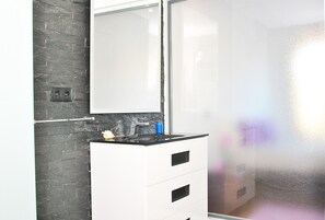 A kitchen with a black tiled backsplash, a white cabinet with a mirror, and a window with frosted glass. - Family villa with BBQ and heatable pool (Albufeira)