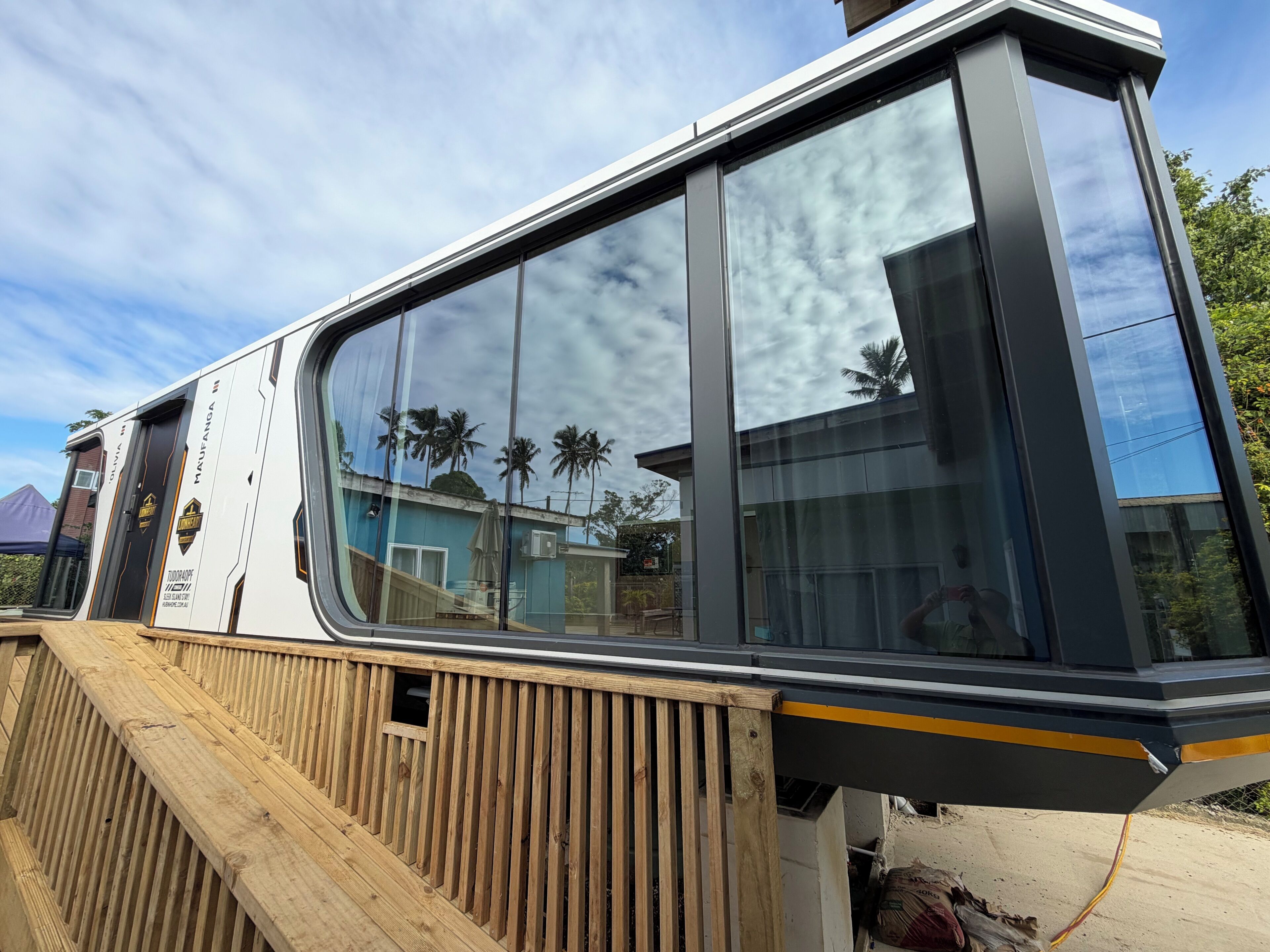 A modern building with large windows and a wooden deck.