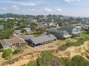 Un quartier résidentiel avec des maisons, un grand bâtiment doté d’une terrasse et un terrain sablonneux.