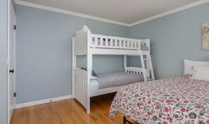 A bunk bed in a room with light blue walls and wooden flooring. - Oceanfront Home with Sweeping Pacific Views (Lincoln City)
