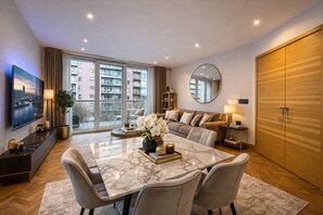 Ein modernes Wohnzimmer mit Essbereich, großen Fenstern und Blick auf eine Stadtlandschaft.