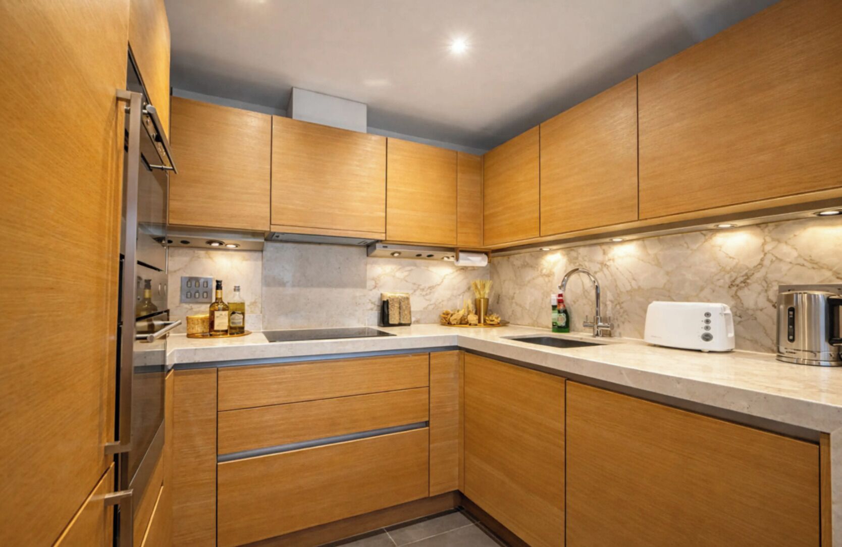 Une cuisine moderne avec des meubles en bois, un plan de travail en marbre et des appareils électroménagers en acier inoxydable.