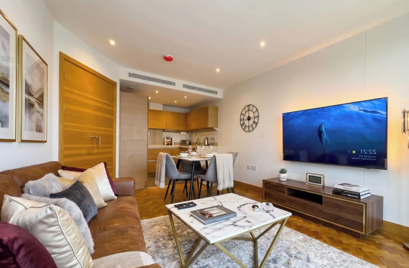 A modern living room with a sofa, coffee table, and a flat-screen TV.