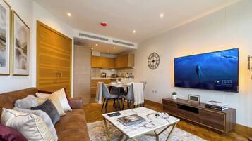 A modern living room with a sofa, coffee table, and a flat-screen TV.