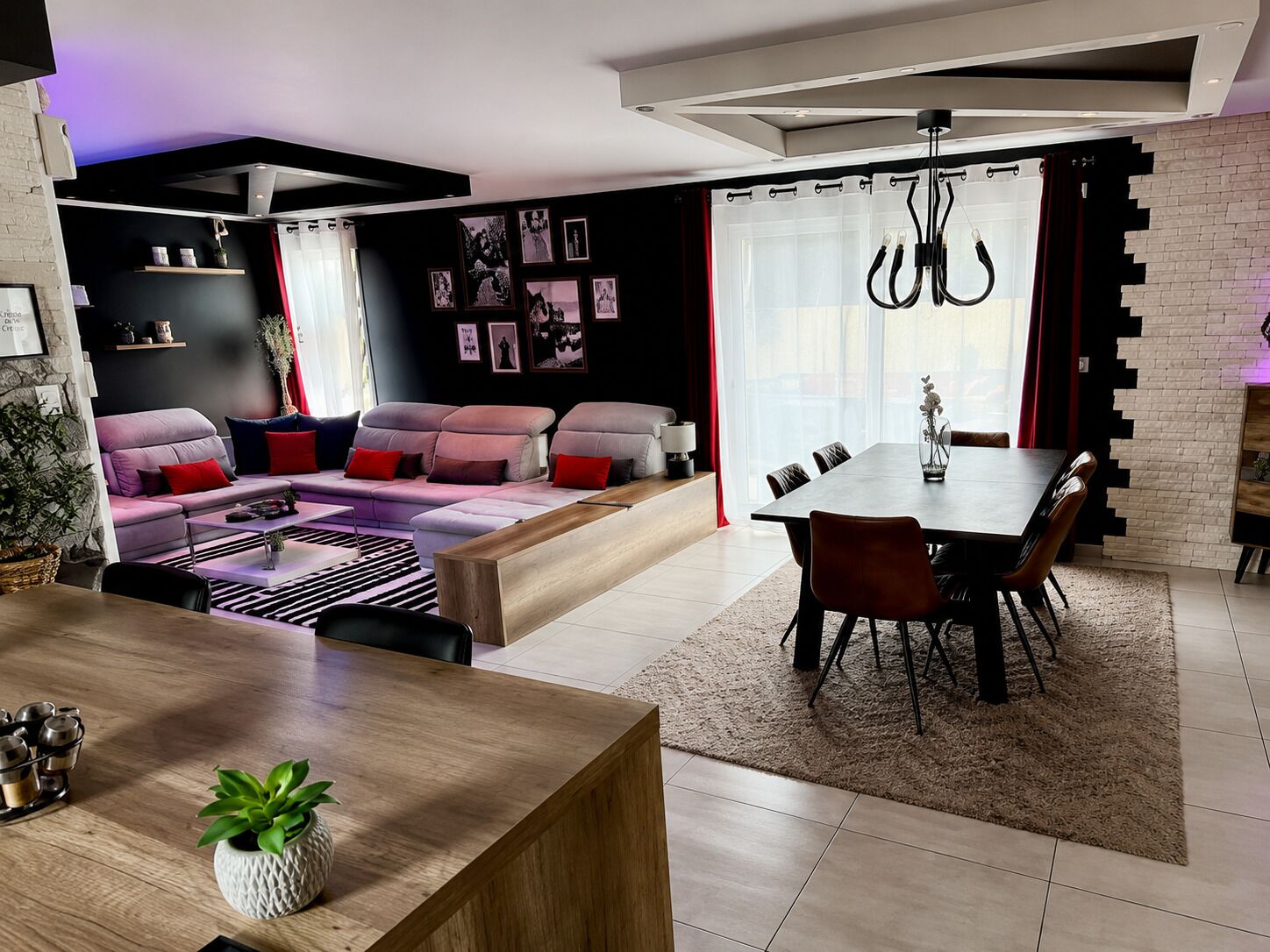 A modern living room with a sofa, dining table, and chairs.