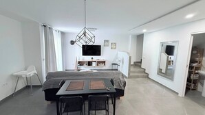 A modern bedroom with a bed, bedside table, and a TV. - Caletillas BlackSand—ocean views—Wi-Fi—garage—2 bedrooms, pool. (Candelaria)