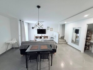 Ein modernes Schlafzimmer mit Bett, Nachttisch und Fernseher.
