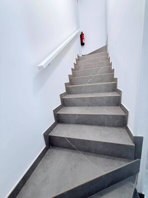 Eine Treppe mit Handlauf und einem an der Wand befestigten Feuerlöscher.