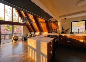 Cocina moderna con una isla grande, techo de madera y vistas a flores de cerezo.