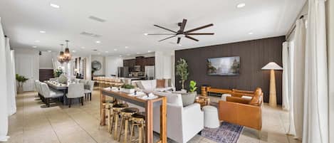 Un amplio salón con una mesa de comedor, sofás y una cocina al fondo.