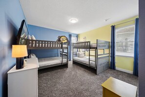 A room with bunk beds, a desk, a lamp, and a window with blinds. - PacMan, Foosball, Shuffleboard, Large Backyard, Chef Kitchen: Metropolis Estate (Kissimmee)