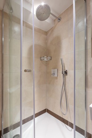 A modern shower enclosure with a glass door, a handheld showerhead, and a wall-mounted control panel. - Lovely 1BR Fitzrovia - Soho (London)