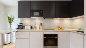 Eine moderne Küche mit integriertem Mikrowellenherd, Toaster und Geschirrspüler.