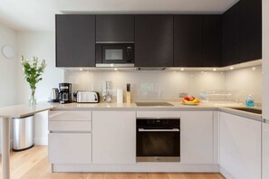 A modern kitchen with a built-in microwave, toaster, and dishwasher. - Lovely 1BR Fitzrovia - Soho (London)