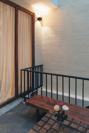 A wooden bench with a vase of flowers, a black metal railing, and a textured wall. - Late Autumn - 3BR private house in vibrant Hanoi - Free airport transport (Hà Nội)