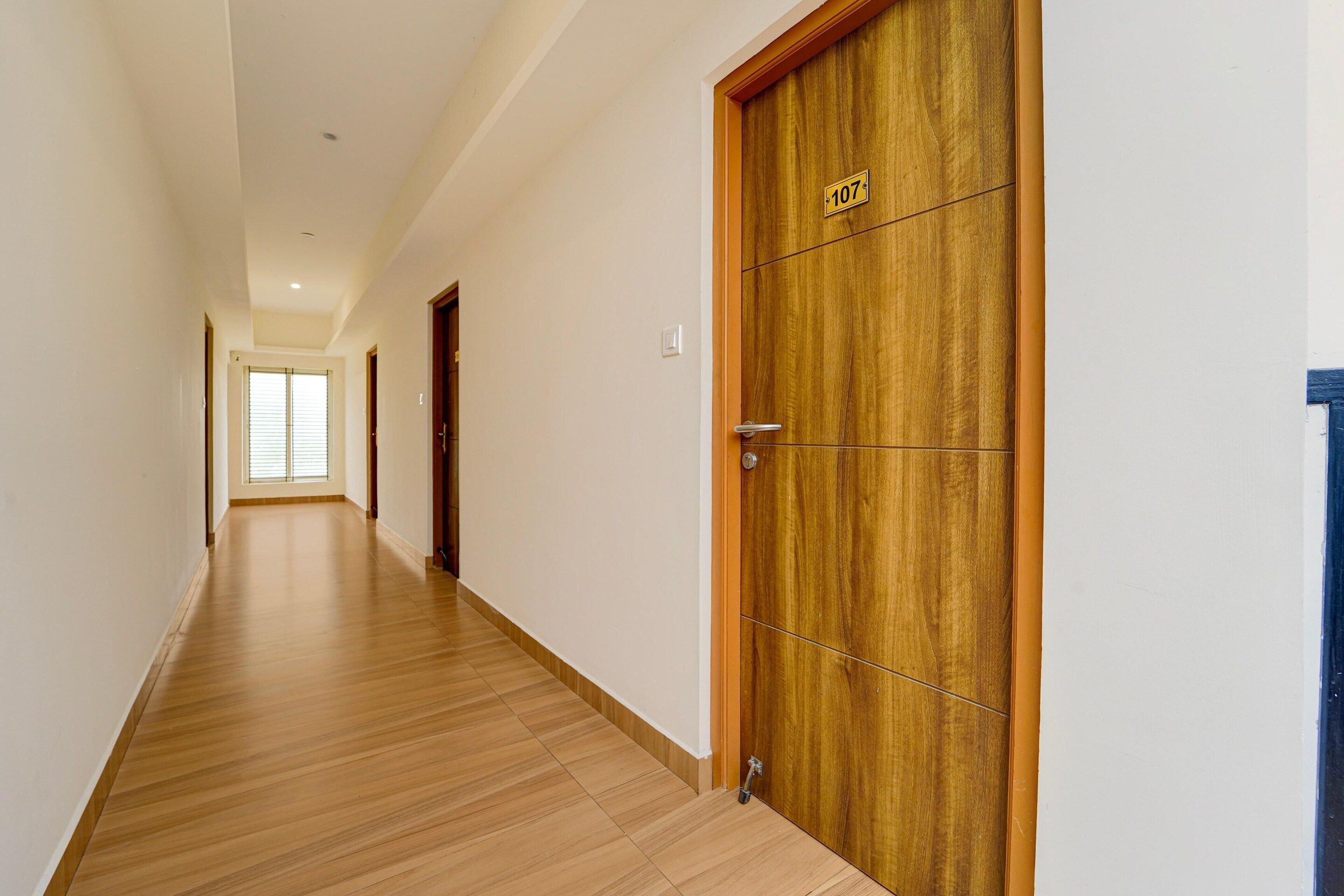 Un couloir doté d’un plancher en bois et d’une porte en bois portant le numéro 107.