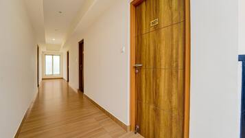Un couloir doté d’un plancher en bois et d’une porte en bois portant le numéro 107.