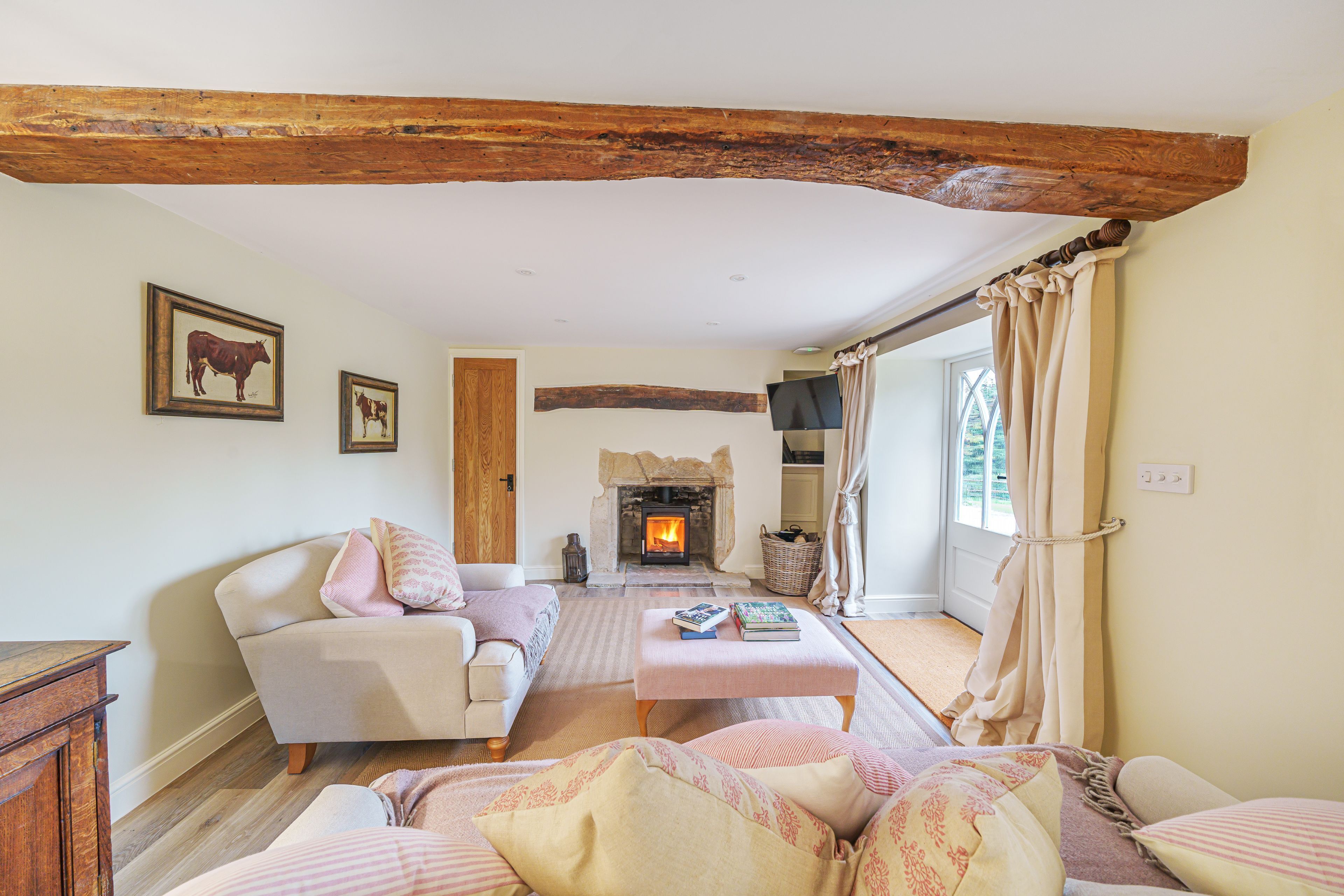 A cozy living room with a fireplace, a sofa, a coffee table, and a television.