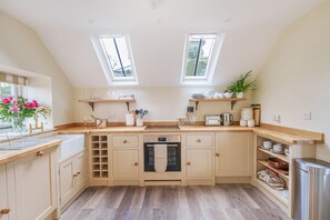 A kitchen with a central island, two skylights, wooden countertops, and a built-in oven. - Puddle Cottage  -  Chebbard, Dorchester (Chebbard)