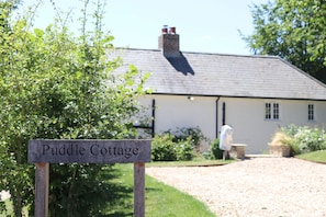 Ein Cottage mit einem Schild, auf dem 'Puddle Cottage' steht.