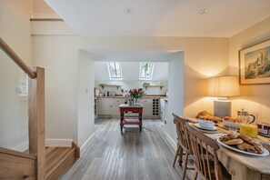 Eine moderne Küche mit Essbereich, Holzboden und einer Treppe.