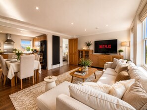 A modern living room with a sofa, a coffee table, and a TV displaying 'NETFLIX'. - Fitzrovia 2-Bed, 2-Bath Apartment | Near Tottenham Court Road (London)