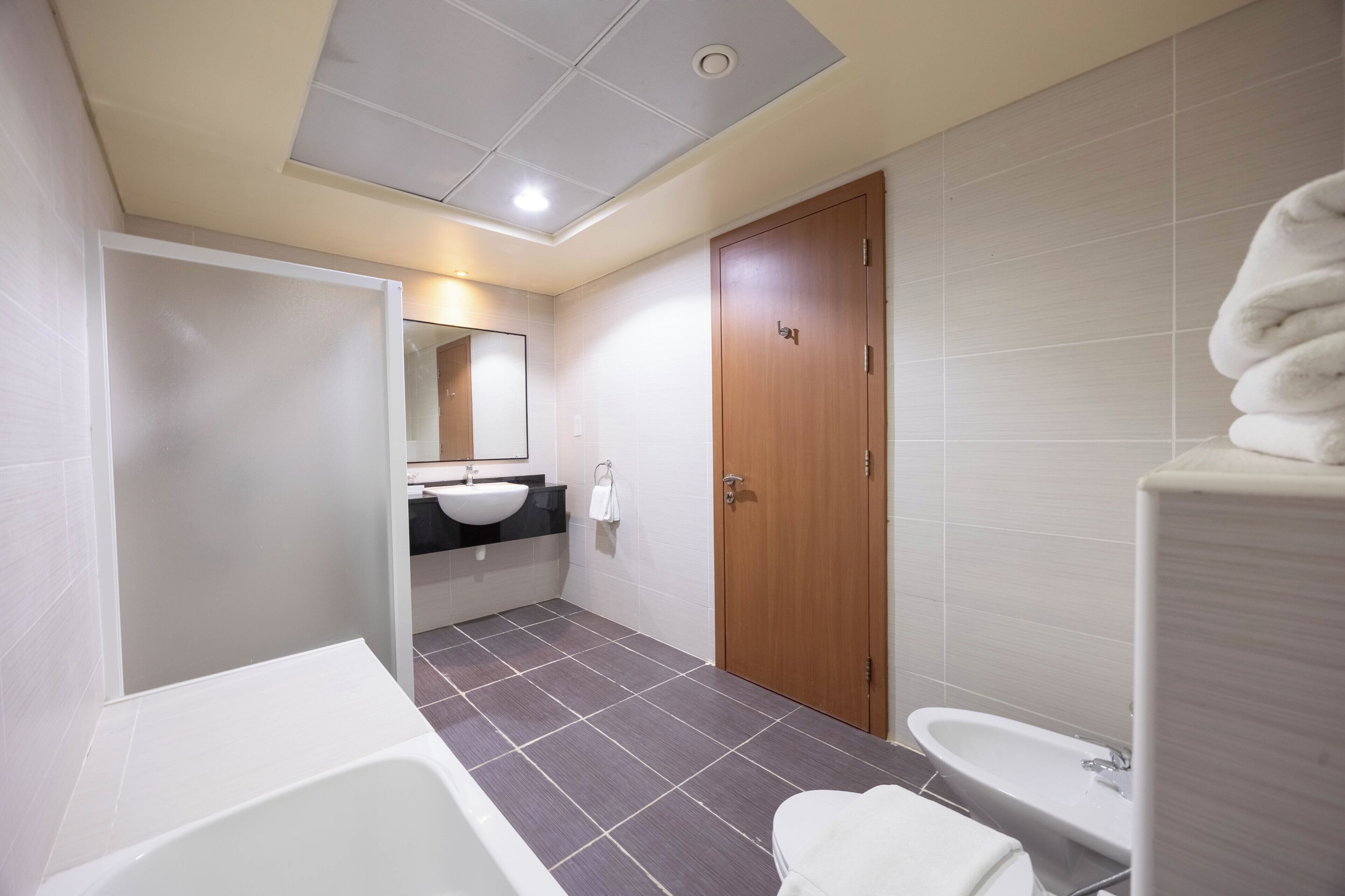 A modern bathroom with a bathtub, a sink, and a toilet.