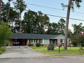 A residential house with a garage, a driveway, and a well-maintained lawn. - Hillwood Circle home with fast EV charger (Augusta)