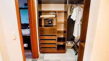 Un vestidor con estanterías de madera, una caja fuerte y un perchero.
