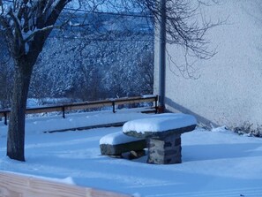 A snow-covered bench and a stone structure in a park setting. - Renovated farmhouse, panoramic view - guests (Vorey)