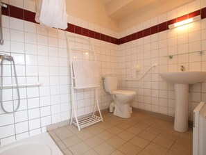 A bathroom with a white bathtub, a toilet, a sink, and a shower with a towel rack. - Cozy house, pets allowed - 5 guests (Saint-Georges-de-Rouelley)