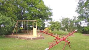 Ein Spielplatz mit Schaukel und Wippe.