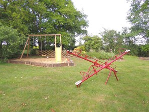 Ein Spielplatz mit Schaukel und Wippe.
