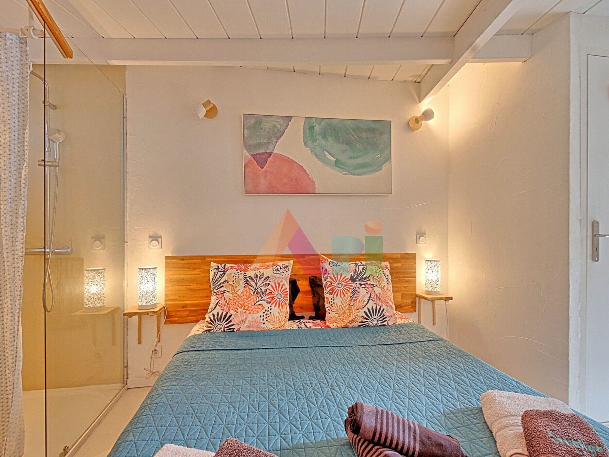 Ein Schlafzimmer mit einem Bett, einer Dusche und einem Wandbild.