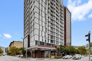 A multi-story hotel with a modern facade, a ground-level entrance, and a visible restaurant sign. - City View 2-bed Apartment Fortitude Valley (Brisbane)