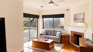 A living room with a sofa, coffee table, fireplace, and a large window with a view.