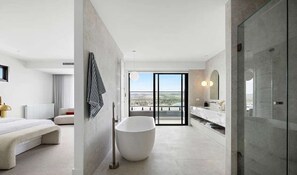 A modern bathroom with a large bathtub, a shower, and a vanity with a mirror. - El v Luxury in Mount Martha With Gas Heated Pool Bay Views (Melbourne)