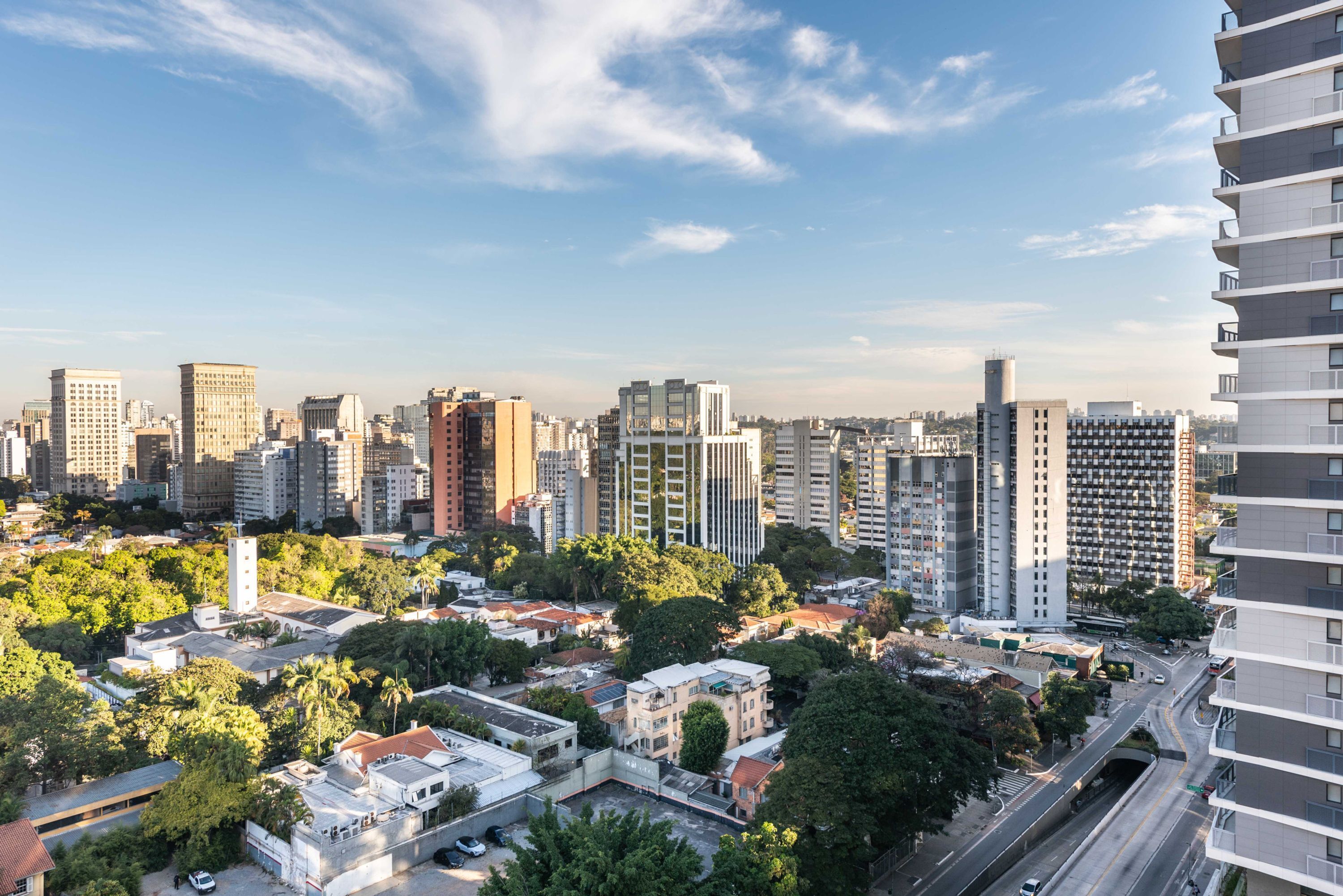 Un paisatge urbà amb edificis alts, una combinació d'edificis residencials i comercials, i un cel serè.