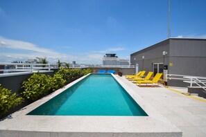 A rooftop swimming pool with a clear blue pool, surrounded by greenery and yellow lounge chairs. - Mc601-1810 You Faria Lima (São Paulo)
