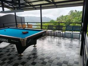 A pool table with a view of a lush landscape. - Avana Hills Tagaytay Manor - Amsterdam (Tagaytay)